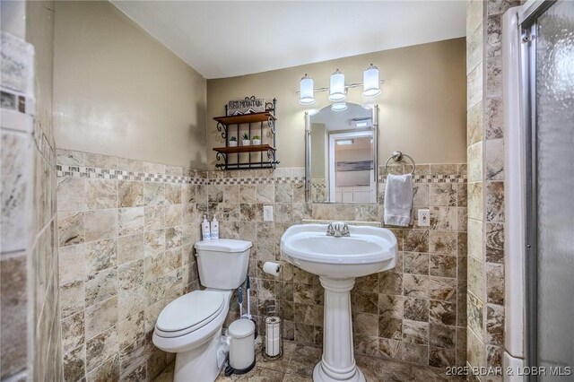 33271 Elaine Rd, Sunrise Beach, MO 65079 - bathroom with toilet, tile walls, and wainscoting