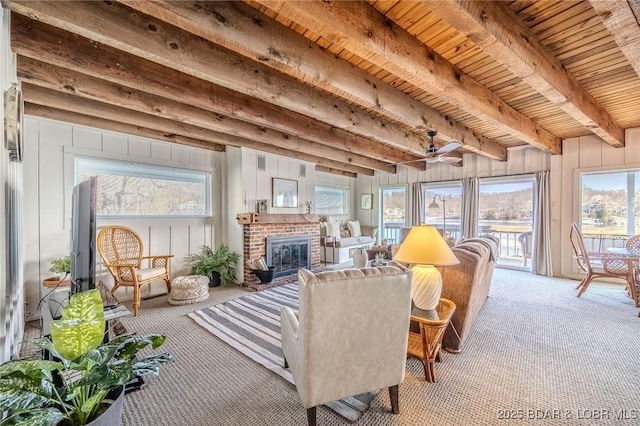33271 Elaine Rd, Sunrise Beach, MO 65079 - living room featuring carpet, a brick fireplace, ceiling fan, and wooden ceiling with exposed beams
