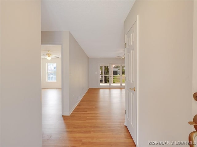 hallway with baseboards and light wood finished floors