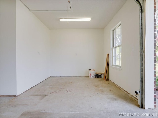 empty room featuring attic access and unfinished concrete floors