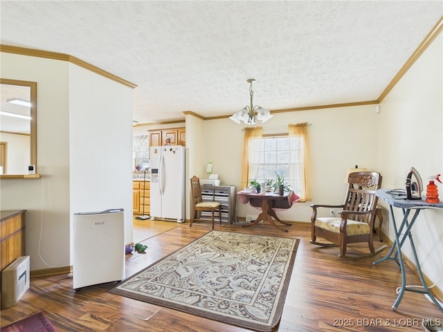 interior space featuring wood finished floors, an inviting chandelier, a textured ceiling, and ornamental molding