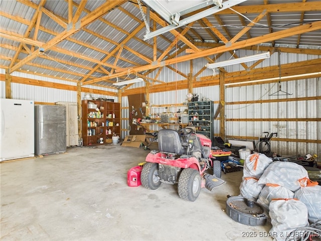 garage with metal wall and freestanding refrigerator