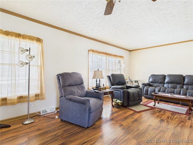 living room featuring wood finished floors, visible vents, crown molding, and a ceiling fan
