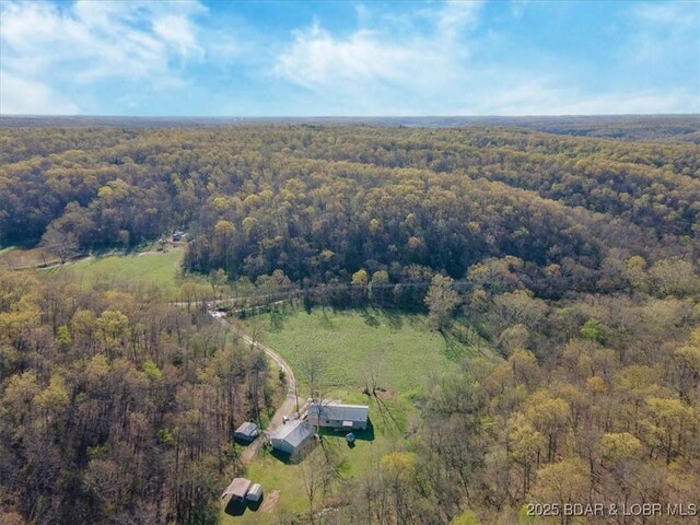 birds eye view of property featuring a forest view