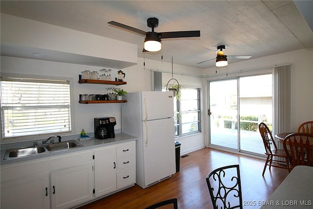 kitchen featuring open shelves, a sink, light wood-type flooring, freestanding refrigerator, and a ceiling fan