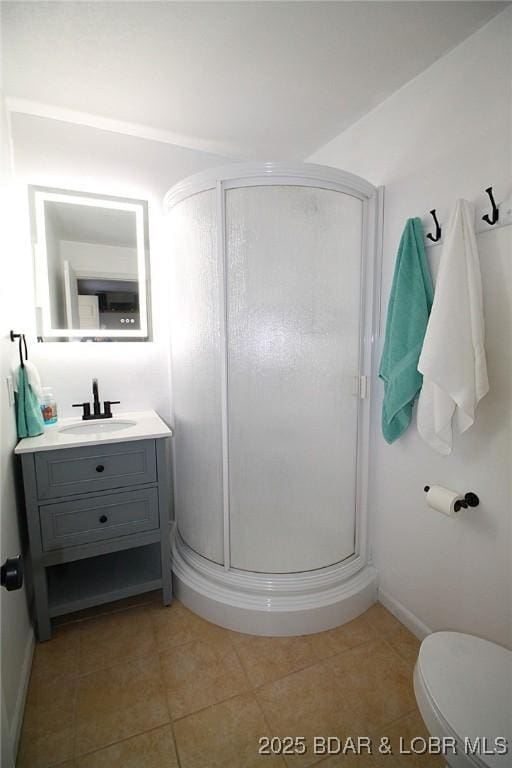 bathroom with toilet, tile patterned flooring, vanity, and a stall shower