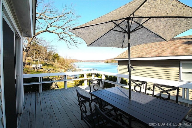 wooden terrace featuring a water view and outdoor dining space