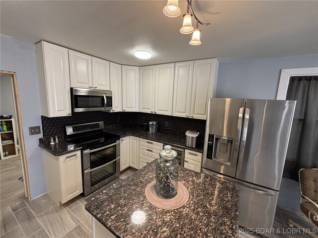 1265 Lick Creek Rd, Edwards, MO 65326 - kitchen with stainless steel appliances, decorative backsplash, and white cabinets