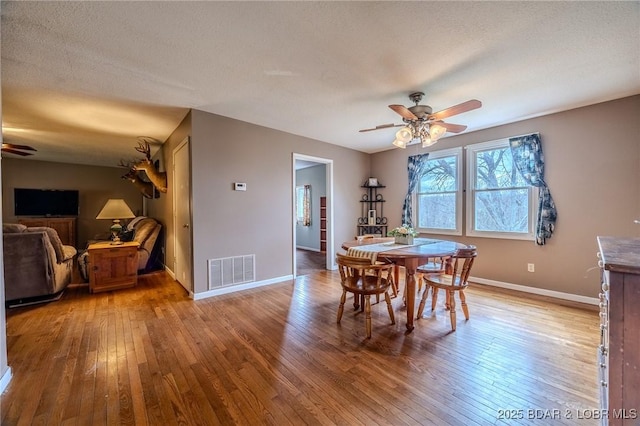 dining room featuring visible vents, light wood-type flooring, and ceiling fan