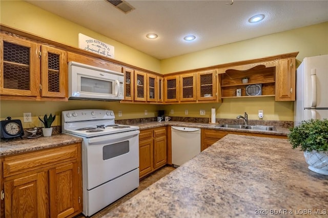 kitchen with recessed lighting, white appliances, glass insert cabinets, visible vents, and a sink