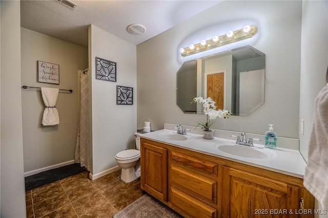 full bathroom featuring toilet, double vanity, a sink, and visible vents
