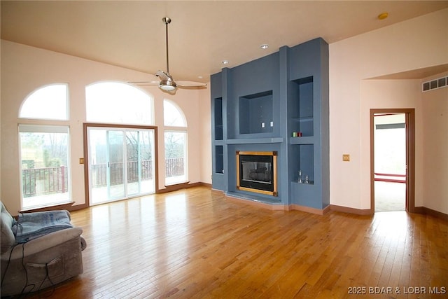 unfurnished living room with light wood-style floors, a healthy amount of sunlight, and visible vents