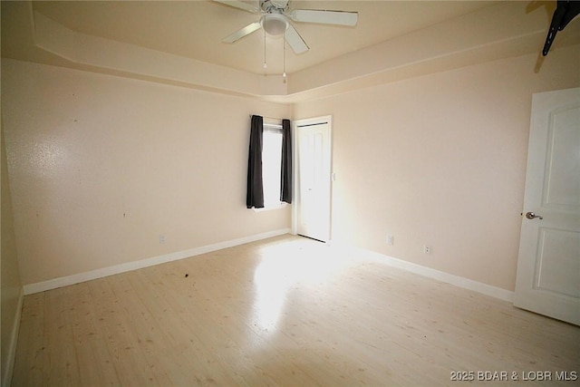 unfurnished room with ceiling fan, light wood-type flooring, and baseboards