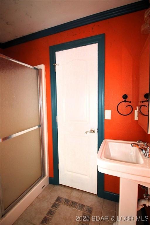 full bathroom featuring a shower stall and tile patterned flooring