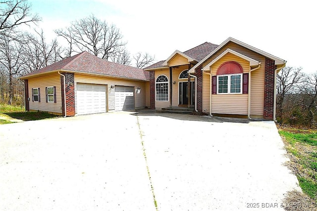 single story home featuring a garage, driveway, and brick siding