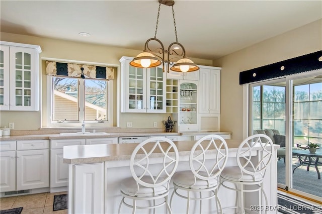 1065 Imperial Point Dr, Four Seasons, MO 65049 - kitchen featuring white cabinetry, light countertops, a breakfast bar, and glass insert cabinets