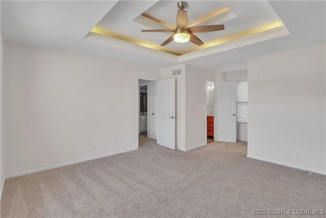 1293 Ginger Rd, Lake Ozark, MO 65049 - unfurnished bedroom featuring a tray ceiling, carpet flooring, visible vents, and baseboards