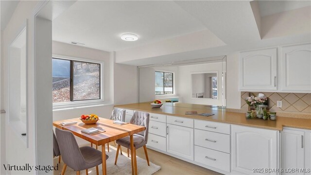 1293 Ginger Rd, Lake Ozark, MO 65049 - kitchen featuring a peninsula, backsplash, plenty of natural light, and white cabinetry