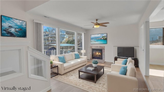 1293 Ginger Rd, Lake Ozark, MO 65049 - living room featuring wood finished floors, a ceiling fan, visible vents, baseboards, and a glass covered fireplace