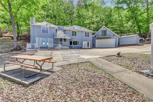 1293 Ginger Rd, Lake Ozark, MO 65049 - exterior space with concrete driveway, a porch, an outdoor structure, and a garage