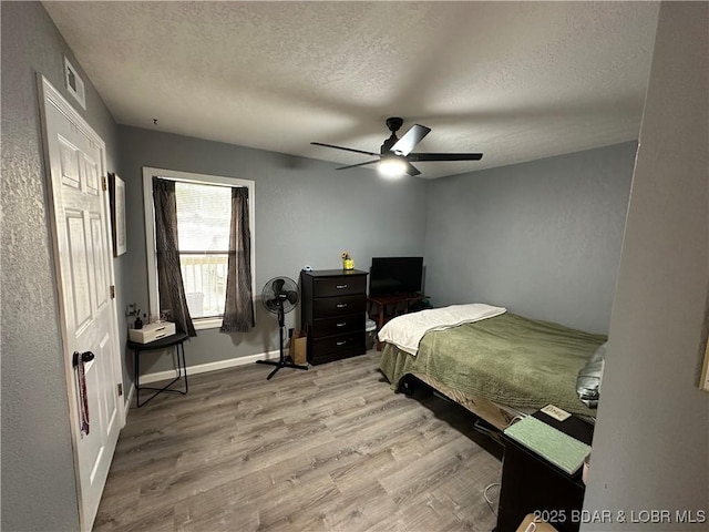 2500 Bay Point Ln Unit 135, Osage Beach, MO 65065 - bedroom with visible vents, a ceiling fan, wood finished floors, and a textured ceiling