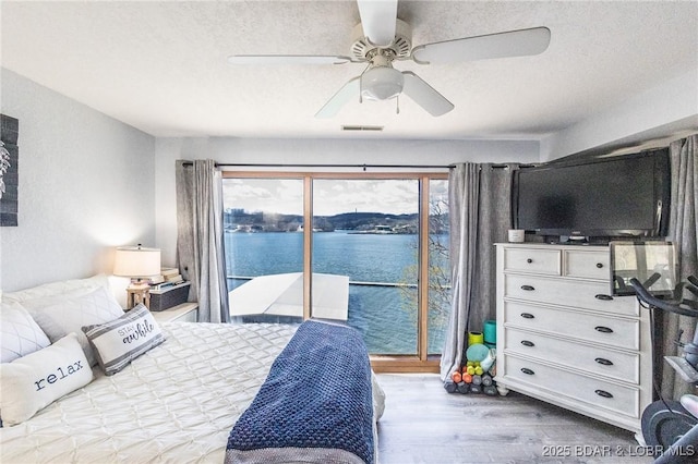 2500 Bay Point Ln Unit 135, Osage Beach, MO 65065 - bedroom with access to outside, ceiling fan, a textured ceiling, visible vents, and wood finished floors