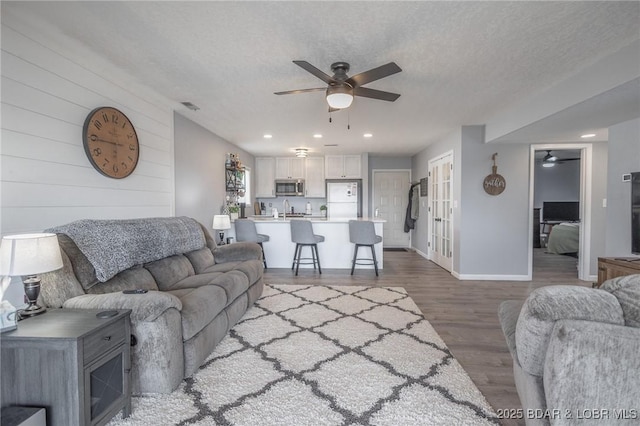 2500 Bay Point Ln Unit 135, Osage Beach, MO 65065 - living area featuring baseboards, ceiling fan, a textured ceiling, wood finished floors, and french doors