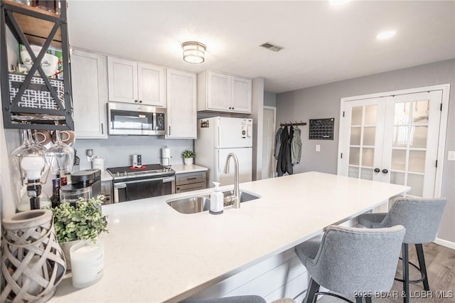 2500 Bay Point Ln Unit 135, Osage Beach, MO 65065 - kitchen featuring french doors, visible vents, appliances with stainless steel finishes, a sink, and wood finished floors