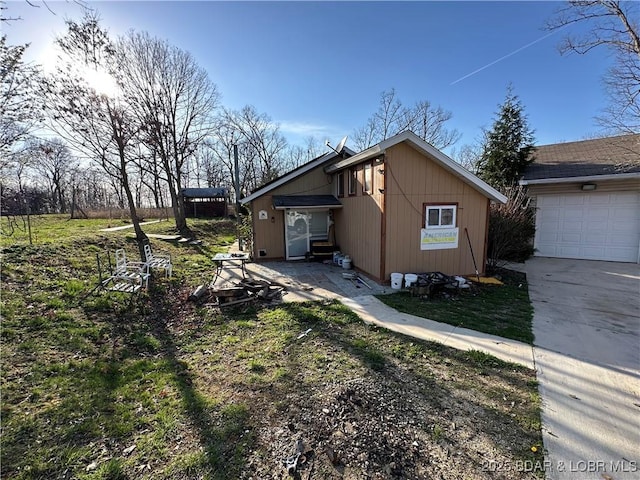 view of side of home featuring concrete driveway