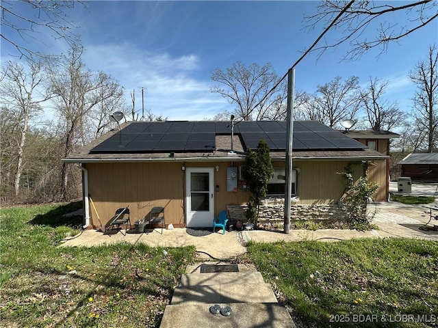 back of property featuring a patio and solar panels