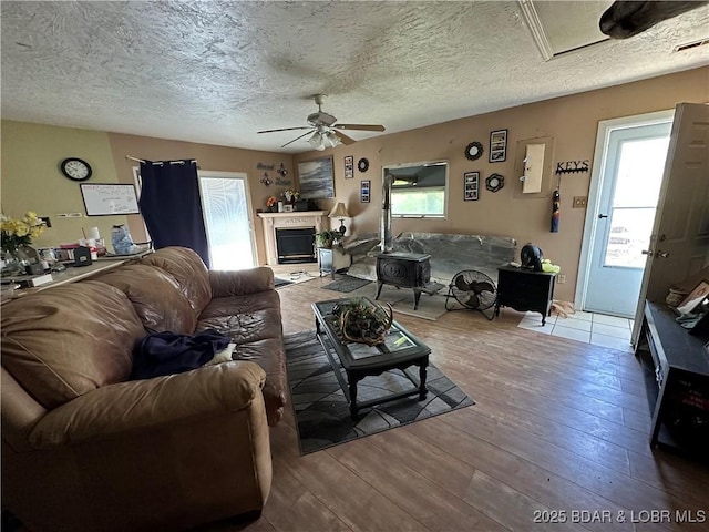24431 Scenic Ridge Rd, Barnett, MO 65011 - living area with a ceiling fan, hardwood / wood-style flooring, a textured ceiling, and a fireplace