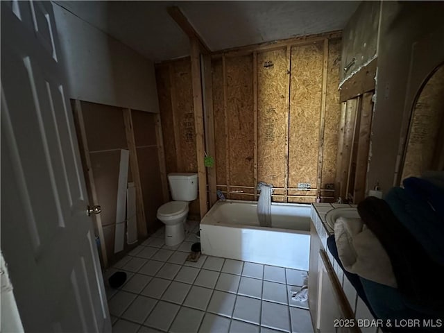 full bath featuring toilet, tile patterned floors, and a bathing tub