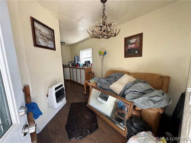 interior space featuring baseboards, heating unit, a chandelier, and wood finished floors