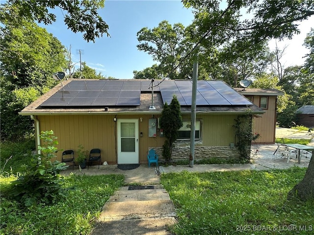 24431 Scenic Ridge Rd, Barnett, MO 65011 - back of house with roof mounted solar panels and stone siding