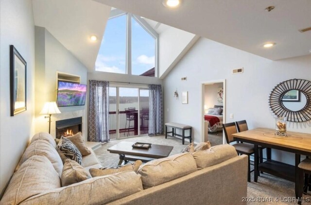 1481 Ledges Dr Unit 1046, Osage Beach, MO 65065 - carpeted living room with high vaulted ceiling, a warm lit fireplace, and recessed lighting