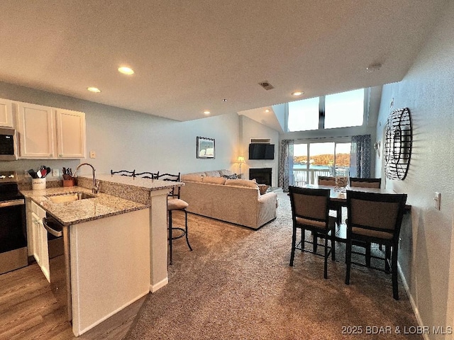 1481 Ledges Dr Unit 1046, Osage Beach, MO 65065 - kitchen with visible vents, a sink, white cabinetry, a peninsula, and stainless steel appliances