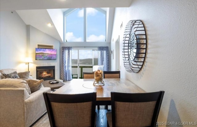 1481 Ledges Dr Unit 1046, Osage Beach, MO 65065 - dining room with a lit fireplace, high vaulted ceiling, and a textured wall