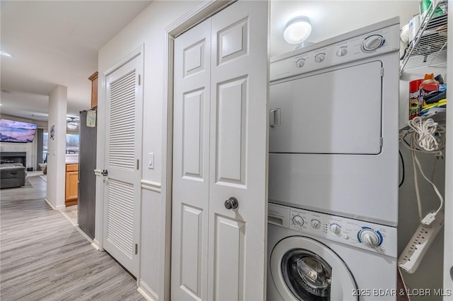 251 Vision Dr Unit 1D, Camdenton, MO 65020 - laundry room featuring light wood-style flooring, laundry area, and stacked washer / drying machine