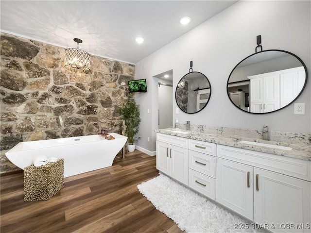 16 Hawk Hill Ct, Lake Ozark, MO 65049 - full bath featuring double vanity, a freestanding bath, wood finished floors, baseboards, and a chandelier