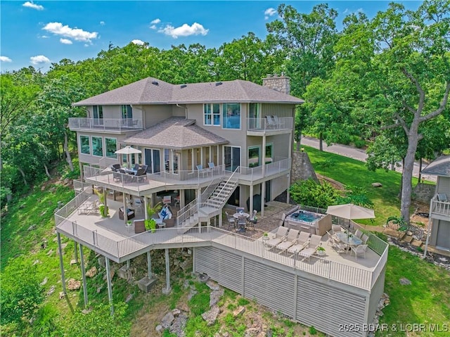 16 Hawk Hill Ct, Lake Ozark, MO 65049 - back of property with a balcony, a patio area, a chimney, and roof with shingles