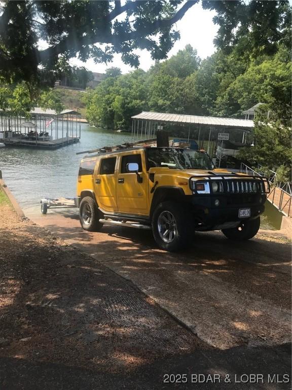 16 Hawk Hill Ct, Lake Ozark, MO 65049 - view of car parking with a water view and a boat dock