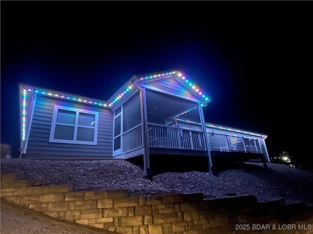 property exterior at night with a sunroom
