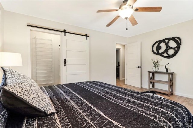 83 Archer Dr, Camdenton, MO 65020 - bedroom with a barn door, light wood-style flooring, baseboards, and ceiling fan