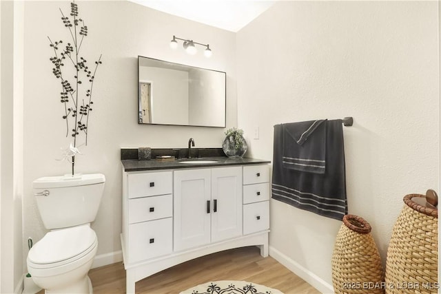 83 Archer Dr, Camdenton, MO 65020 - half bathroom featuring vanity, baseboards, toilet, and wood finished floors