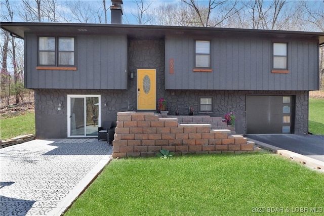 83 Archer Dr, Camdenton, MO 65020 - split foyer home featuring a garage, aphalt driveway, stone siding, and a front lawn