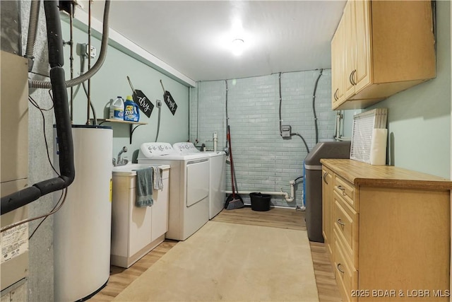 83 Archer Dr, Camdenton, MO 65020 - laundry area featuring cabinet space, light wood-type flooring, separate washer and dryer, and water heater
