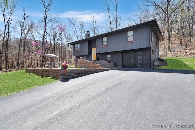 83 Archer Dr, Camdenton, MO 65020 - bi-level home featuring a front yard, driveway, and an attached garage