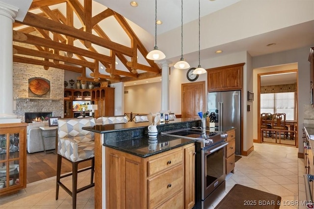 406 N Point Dr, Camdenton, MO 65020 - kitchen with appliances with stainless steel finishes, decorative columns, light tile patterned floors, high vaulted ceiling, and a breakfast bar