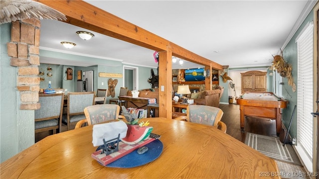 dining room with crown molding, wood finished floors, and beam ceiling