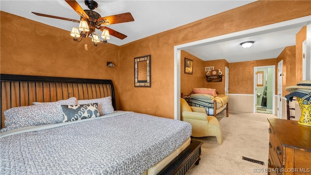 carpeted bedroom featuring ceiling fan and a textured wall
